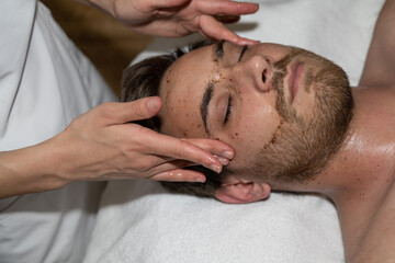 Fototapeta na wymiar Soin esthétique d'un homme en salon, massage du visage