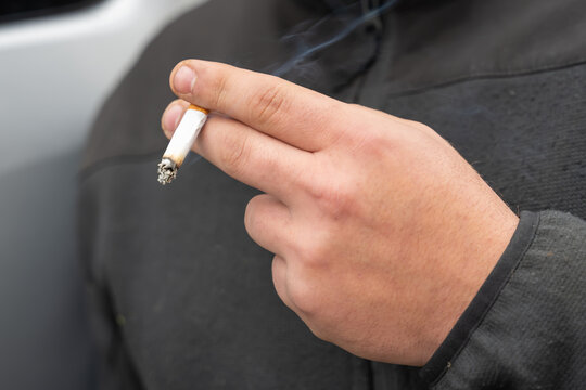 Main d'un fumer avec une cigarette
