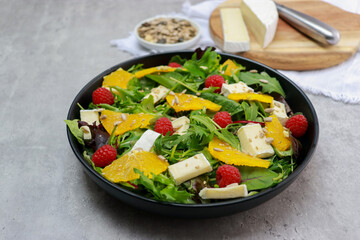 close up of a fresh green salad with oranges and brie cheese 