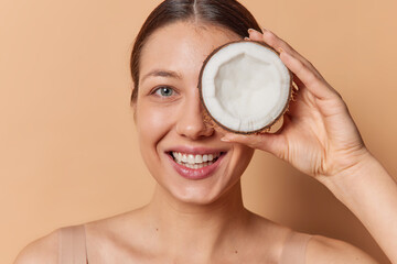 Beauty coconut and skin care concept. Dark haired woman with natural and diy facial product for...