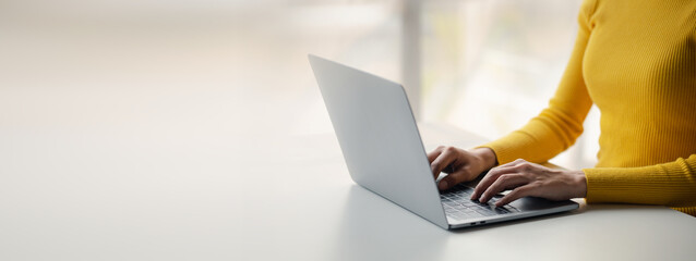 Person typing on laptop keyboard, businessman working on laptop, he is typing messages to...