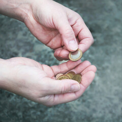 A person is holding a stack of coins in their hands.