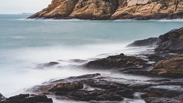 Beautiful landscape of splashing waves at the rocky shore © Zeron Tam/Wirestock Creators