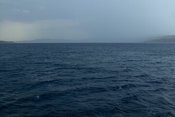 Obraz premium Scenic shot of the wavy sea surface under the stormy sky