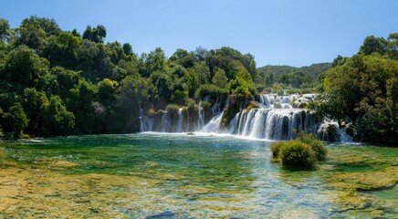 Scenic view of a waterfall flowing through green trees in Krka national park, Croatia on a sunny day