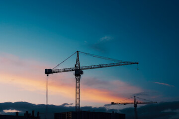 Fototapeta na wymiar Construction crane at twilight, with cityscape background. High quality generative ai