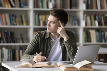 Pensive student guy stuck on difficult task for hours without progress, staring aside feels annoyed...