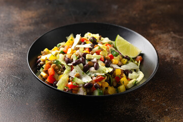 Mexican style salad of black beans, lentils, corn, tomato and lettuce with a salsa and tortilla chips
