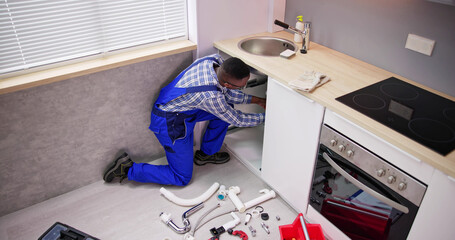 Plumber Cleaning Kitchen Drain And Pipe