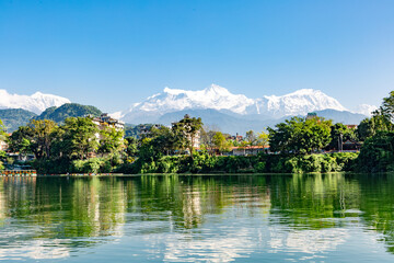 Fototapeta na wymiar View over The Himalayas from the Phewa lake shore in Pokhara, Nepal.