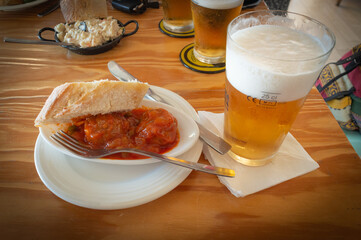 Tapa de albóndiga con tomate y copa de cerveza