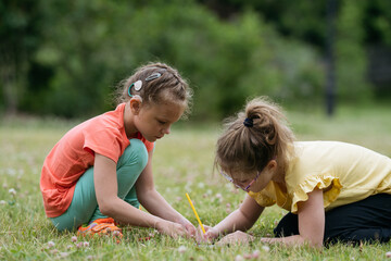Two 8 years old girls drawing together in park.