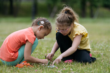 Two 8 years old girls playing together in park. Little girl with hearing aid.