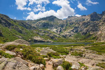 Fototapeta na wymiar Hiking trail to the beautiful mountain Melo lake, Lac de Melo, in Restonica valley in Corsica.Mountain landscape of Lac du Melu, Melu Lake in the Restonica valley in central Corsica, France