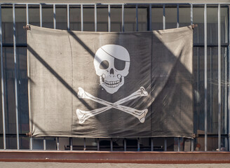 Bandera pirata de fondo negro, con dos tibias y una calavera.