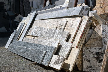 Warehouse of decorative stone in the open air. Marble and granite cuttings for production.