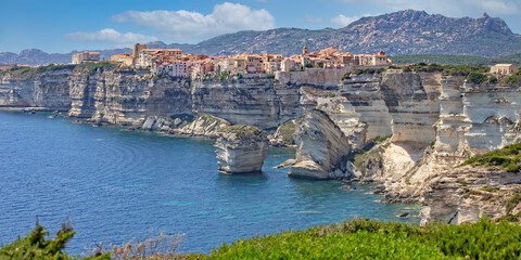 Bonifacio at the edge of the chalk cliffs. Bonifacio is situated on the cliffs of a limestone peninsula sculpted and eroded by the sea, with buildings overhanging the edge, Corsica island, France