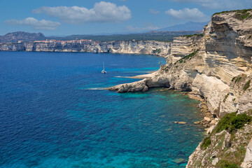 Obraz premium Landscape view of the famous chalk cliffs of Bonifacio. The famous rugged chalk cliffs and turquoise blue sea coast at Bonifacio, Capo Pertusato, Corsica island, France