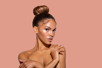 Obraz premium Young African American Woman with Perfect healthy smooth Skin touches her shoulders with her hand and looks at the camera. isolated. colored gentle background. Fashion Portrait beautiful black woman. 
