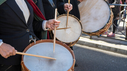 Fototapeta na wymiar Tres músicos tocando instrumentos de percusión, tambores, en la calle durante una procesión de semana santa en Valladolid, España