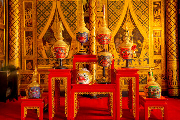 Fototapeta premium Beautiful ancient traditional Thai pattern Pantomime or Khon masks are set up on wooden shelves with Thai painting as background of public place in Thailand.