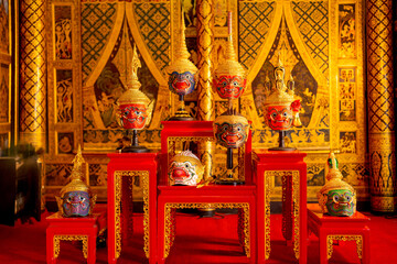 Beautiful ancient traditional Thai pattern Pantomime or Khon masks are set up on wooden shelves...