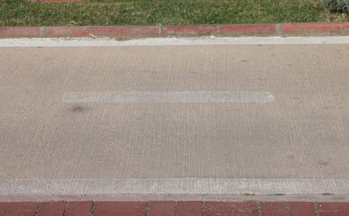 Fototapeta premium view of empty road bike path and highway in the city, curb stone and white road markings, minimalism.
