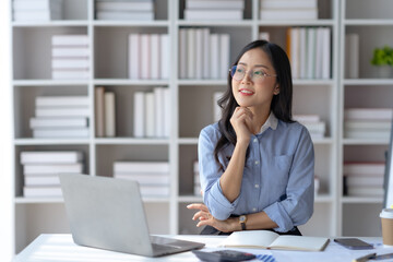 Charming Asian businesswoman working with a laptop at the office.