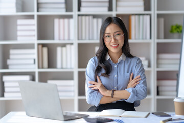 Beautiful and confident Asian businesswoman arms crossed thinking new idea at office.