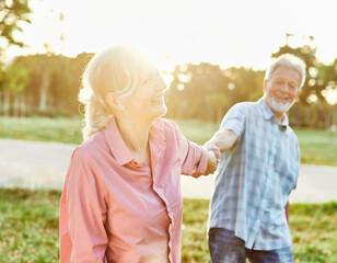 Fototapeta na wymiar woman man senior couple happy retirement together elderly active vitality park fun smiling love old nature wife happiness mature walking holding hands