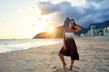 full body portrait young brazilian woman posing and smiling happy on Ipanema beach in Rio de...