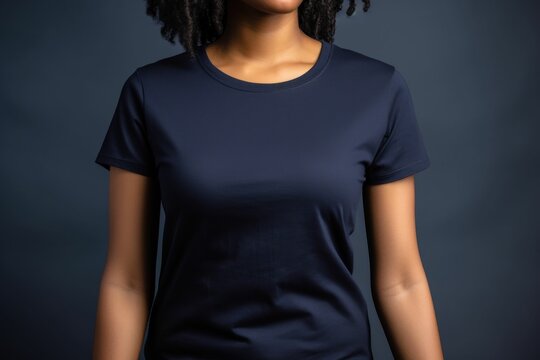 Black woman model wearing a plain navy blue short sleeved t-shirt, isolated on a blank background. Mock-up, torso only. Generative AI illustration.