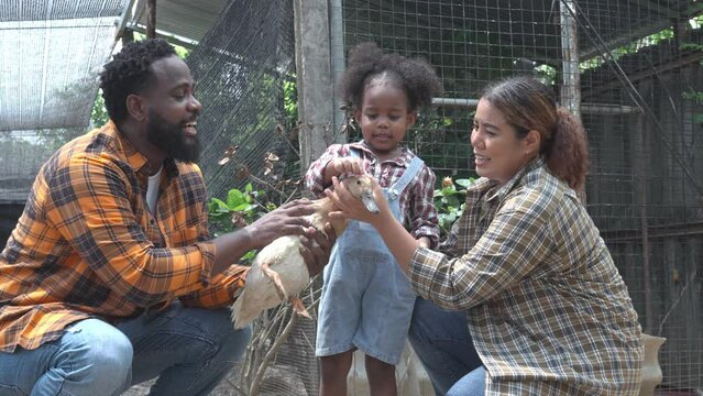 Family love of happy mom, dad and child enjoy time feeding the Duck in the farm, talking and bond on countryside field. 