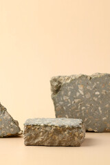 Minimal stone podium display on beige background. Pedestal for natural cosmetics presentation, beauty products display.