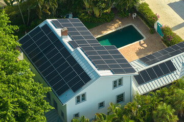 Big new residential house in USA with rooftop covered with solar photovoltaic panels for producing...