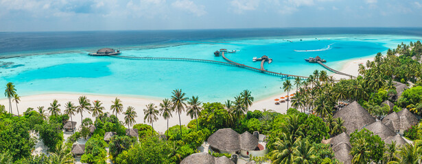 Tranquil aerial landscape, luxury tropical resort with water villas. Beautiful island beach palm trees sunny sea sky. Amazing bird eyes panoramic Maldives paradise coast. Exotic vacation travel beach
