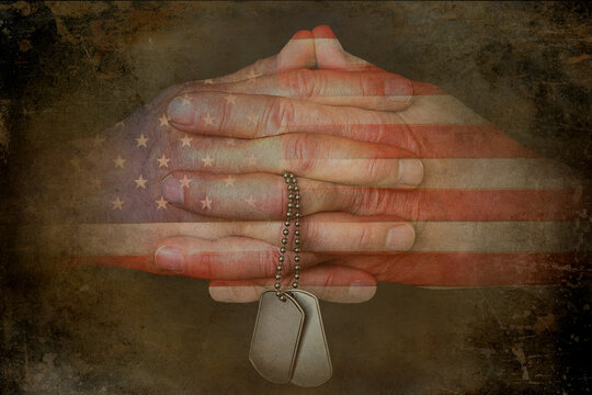 American flag pattern on praying hands holding military dog tags