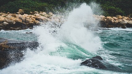 Dramatic shot of strong waves hitting the rocky shore of Shek O in Hong Kong