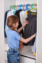 How to organize your wardrobe. Vertical storage of clothing in wardrobe. White closet in kids room. 