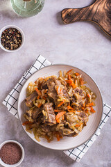Stewed beef oxtail with wine and vegetables on a plate on the table top and vertical view