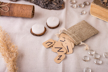 Handmade cardboard Scandinavian divination runes fall out of the pouch on the table