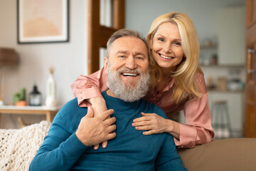Portrait Of Happy Mature Couple Hugging Sitting At Home