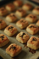Selective shot of homemade black sesame scones placed on a baking tray