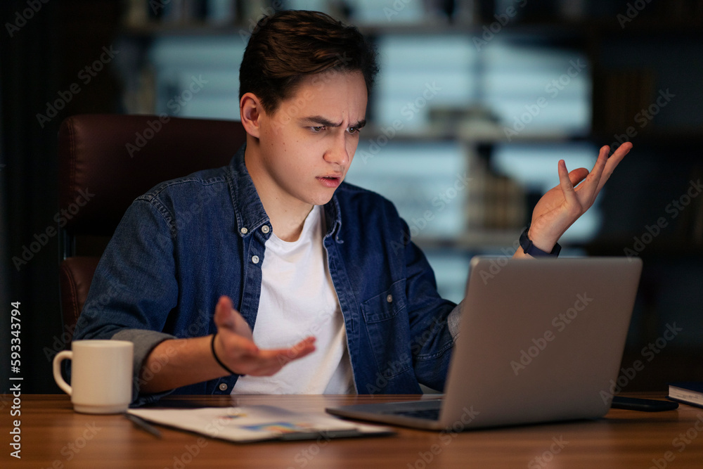 Wall mural irritated angry young man employee working on laptop at office