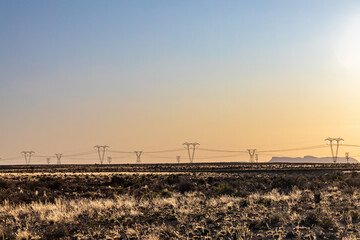 High-voltage power lines at sunset, high voltage electric transmission towers in the Karoo area of...