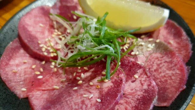 Japanese style yakiniku thin slices beef tongue gyutan bbq roast with lemon green onion sesame