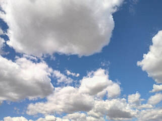 Mass of whitish clouds move in the intense blue sky