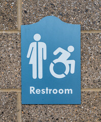 A blue sign for a public restroom signifying it can be used by men, women and handicapped people on...