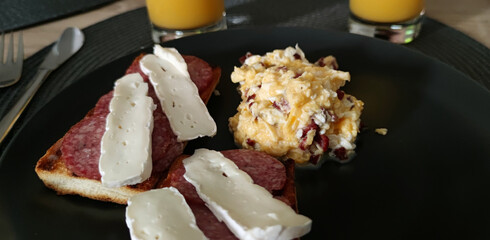 Close-up view of a sandwich with salami and cheese and scrambled eggs