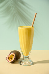 Passion Fruit Lassi on blue background with summer shadow. Vertical format. Indian healthy beverage...